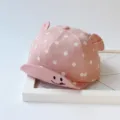 Nahaufnahme der rosafarbenen Pünktchen Baby-Baseballkappe mit Ohren und Lächeln-Detail. - Einheitsgröße verstellbar (ca. 48 cm) / Rosa