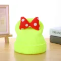 Detailed view of bright neon green knitted beanie hat featuring a cute red white polka dot bow. - Around 50cm / Yellow-Green