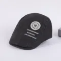 Detail view of dark grey cotton flat cap with embroidered fashion badge and lettering text. - Adjustable / Dark Gray