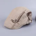 Close up of men cotton flat cap detail, khaki color with embroidery and skull rivet. - Adjustable / Beige
