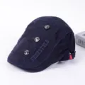 Detailansicht der dunkelblauen Schiebermütze mit Freestyle-Stickerei und Metallknöpfen. - Verstellbar / A-Marineblau