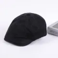 Close-up detail of the classic black cotton flat cap, showcasing fine stitching and texture. - Adjustable / Black