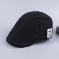 Detail of black cotton flat cap with side logo patch, retro ivy newsboy hat for men. - Adjustable / Black