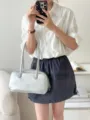 Silver metallic underarm shoulder bag detail, featuring sleek handles and minimalist style. - Silver