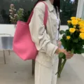 Detailed view of stylish pink shoulder bucket bag in modern aesthetic lifestyle setting. - Pink