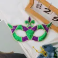Flonkerend pailletten masquerade masker in levendige groene en paarse feeststijl. - Driekleurige pijl