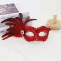 Red sequin masquerade mask with feathers and rhinestones, perfect for festive party events. - Red