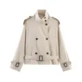 Detailed close-up view of the beige cropped trench coat featuring a stand collar and belt. - XS / Beige