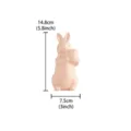 Detailed view of the cute pink ceramic Easter bunny rabbit ornament holding an egg with size dimensions. - Right / Pink