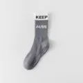 Grey white mid-tube yoga grip socks with non-slip silicone soles and stylish typography. - One Size / Dark Gray