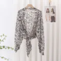 Detailed view of black and white printed sheer chiffon sun protection cardigan with front tie. - Style 3