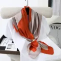 Detail view of a 90cm satin square scarf with chic geometric color blocks and a pearl buckle. - Style 5