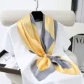 Details of the yellow and grey geometric silk square scarf with pearl clip display. - Style 1