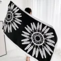 Close-up detail of the black and white ethnic feather pattern shawl and decorative scarf. - L298
