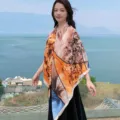 Floral 130 large square scarf detail showing vibrant abstract orange pattern worn outdoors gracefully. - Style 1
