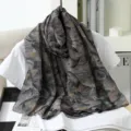 Detailed view of the stylish large faux silk scarf featuring an elegant floral print design. - 2