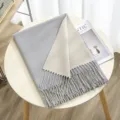 Detailed view of the winter reversible cashmere feel scarf with fringe in grey and beige. - Color 24