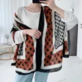 Vue détaillée d'une écharpe écossaise orange et noire pour femme, texture douce et confortable. - Plus de 175cm / Football rouge rouille