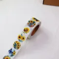 Detailed view of a roll of 500pcs vintage sunflower butterfly journal sealing stickers. - CX-142