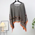 Detailed view of the women's faux silk poncho shawl with classic carriage and chain print. - Style 10