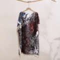 Detail view of a women's abstract print sunscreen shawl, loose off-shoulder summer top. - 26