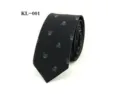 Close-up detail of a black men necktie featuring a stylish gothic skull pattern. - Black