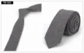 Primer plano de una corbata estrecha de hombre en algodón gris con sutiles rayas finas. - TW-004 (Gris)