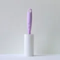 Lint roller with purple handle and white sticky paper roll for clothes and pet hair removal - Lilac Purple