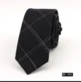 Detailed view of a black cotton slim plaid necktie with white stitched grid pattern for men. - MG-094