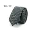 Detail view of a stylish grey wool plaid necktie with blue grid pattern for formal business wear. - WOOL-002