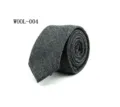Close-up detail of a stylish mens grey wool plaid necktie rolled up neatly for business attire. - WOOL-004