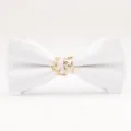 Gros plan détaillé d'un nœud papillon en tissu blanc avec un élégant anneau en métal doré. - Blanc