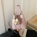 Schicke rosa Leder-Eimer Tasche für Damen mit niedlichem Welpen-Plüsch-Anhänger und Henkeln. - Mit Anhänger / Lila
