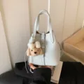 Stilvolle hellblaue Leder-Eimer Tasche mit süßem Plüsch-Welpen-Anhänger und Schultergurt. - Mit Anhänger / Blau