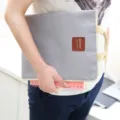 Grey oxford canvas laptop sleeve and document bag with handle, held in hand, main view product. - Pink