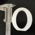Gedetailleerd aanzicht van wit houten letterornament met schuifmaat voor decoratie rekwisieten. - Witte Letter O
