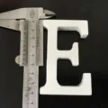 Closeup white wooden letter E ornament, ideal for home decor, wedding props and shooting photos. - White Letter E