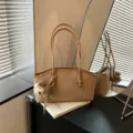 Minimalistische Schultertasche im Baguette-Stil für Damen, schicke Freizeittasche mit Bärenanhänger. - Khaki Mit Anhänger