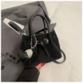 Stylish black woven crossbody bag for women, chic bucket handbag with metal buckle and heart charm. - With Pendant / Black