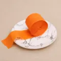 Orange crepe paper roll, 4.5cm wide and 22m long, perfect for party backdrop and DIY crafts. - Orange