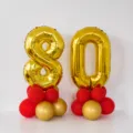 80th birthday golden number balloon set with red and gold balloon bases for party decoration. - 80th Birthday Gold Number Balloon Column