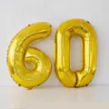 Gold number 60 foil balloons for birthday party celebration and anniversary decoration setup. - 32-Inch Gold Number 60 Balloon