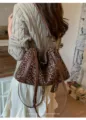 Detalle del bolso tote con estampado de leopardo, tiras de cuero marrón y candado. - Estampado de leopardo