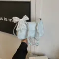 Stylish light blue shoulder bag for women, featuring lace bow and braided handle design. - Green