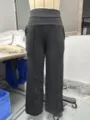 Dettaglio di pantaloni neri a vita alta ampi con cintura incrociata e piega centrale. - Taglia S / Colore 13