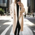 Detailed view of the elegant beige oversized woolen long coat, showcasing premium fabric texture. - S / Apricot