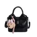 Borsa a mano nera lucida con ciondolo cane in peluche con fiocco, borsa a tracolla elegante. - nero con ciondolo