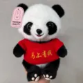 Close-up detail of a cute plush panda toy wearing a red knitted sweater with embroidery. - Panda in "Get Rich Immediately" Sweater / 25cm