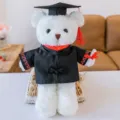 Detalle de primer plano de osito de peluche blanco con toga negra y birrete de graduación. - 30cm / Oso blanco con cuello rojo y borlas rojas
