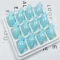 Close-up of iridescent acrylic carrot beads in white tray for DIY handmade phone chain. - Lake Blue